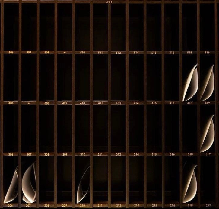 Postales artísticas colocadas en una estantería numérica de madera, imagen conceptual para ROUCLÊ.