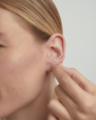 Mujer colocando el Piercing Oreja Helix en la parte alta de la oreja.